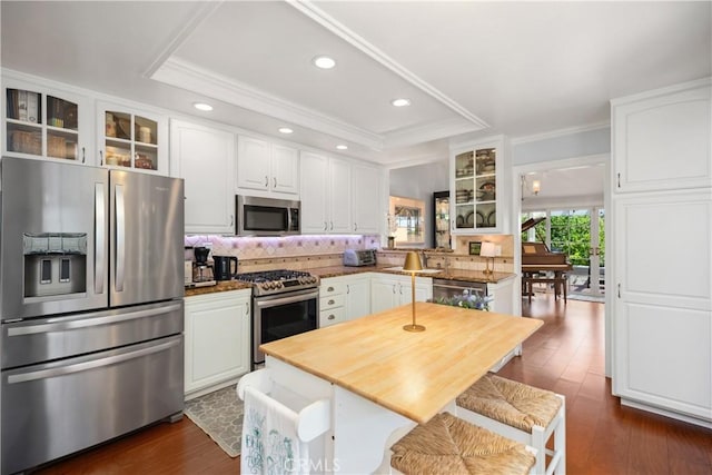 22876 Montalvo Rd, Laguna Niguel, CA 92677 - kitchen with stainless steel appliances, glass insert cabinets, decorative backsplash, white cabinets, and crown molding