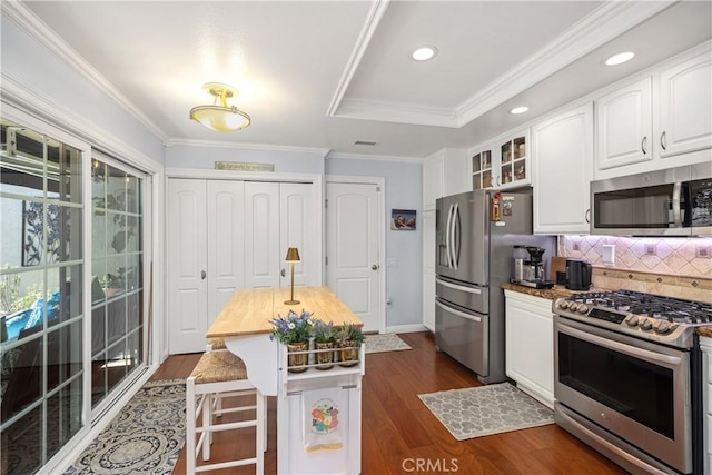 22876 Montalvo Rd, Laguna Niguel, CA 92677 - kitchen with appliances with stainless steel finishes, wood counters, white cabinets, decorative backsplash, and recessed lighting