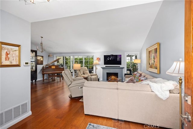 22876 Montalvo Rd, Laguna Niguel, CA 92677 - living room with vaulted ceiling, wood finished floors, a chandelier, and a lit fireplace