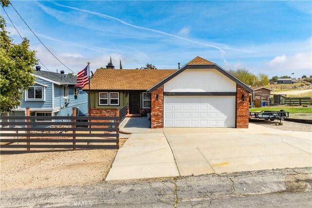 single story home featuring fence, driveway, an attached garage, and brick siding