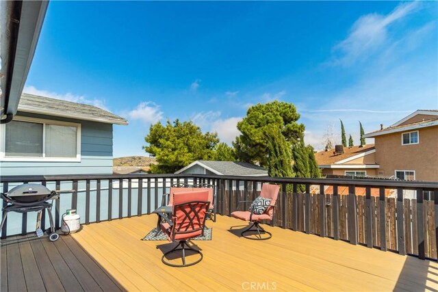 wooden deck featuring a grill