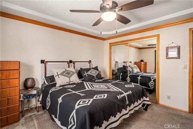 carpeted bedroom featuring baseboards, crown molding, a closet, and a textured ceiling