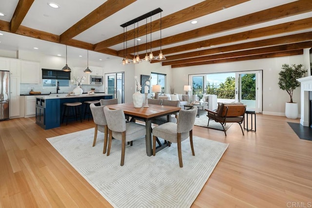 2264 Soto St, San Diego, CA 92107 - dining area with beamed ceiling, light wood-style flooring, recessed lighting, baseboards, and a fireplace with flush hearth
