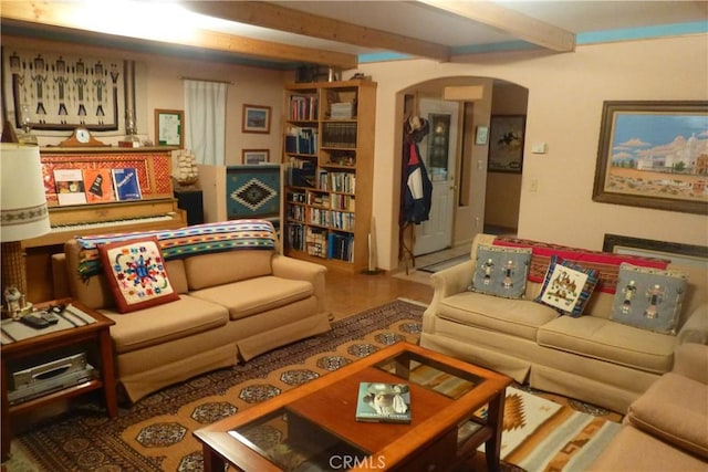 living area featuring arched walkways and beamed ceiling