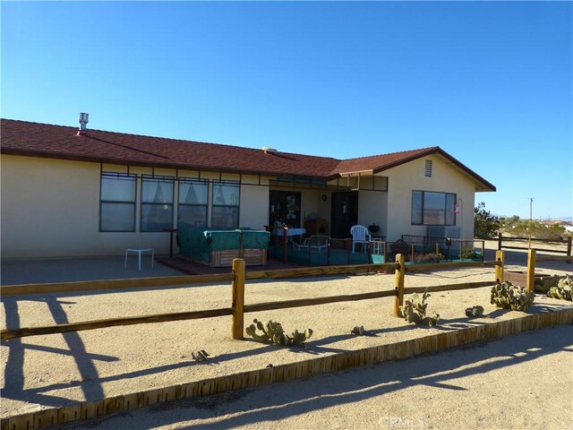 ranch-style house with fence, stucco siding, and a patio area
