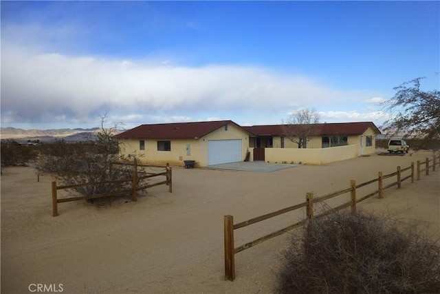 single story home featuring stucco siding, driveway, a garage, and fence