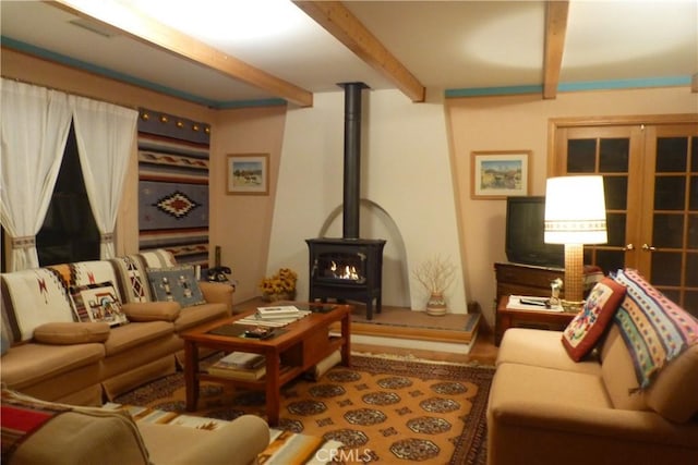 living area featuring a wood stove and beamed ceiling