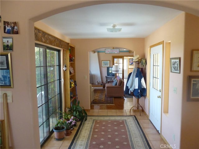 entrance foyer featuring arched walkways and light tile patterned floors