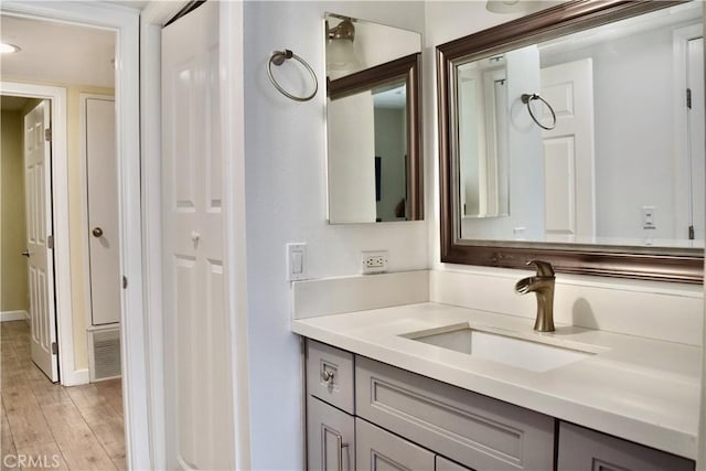 bathroom with visible vents, wood finished floors, and vanity