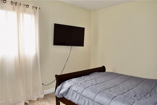 bedroom with light wood-style flooring and baseboards