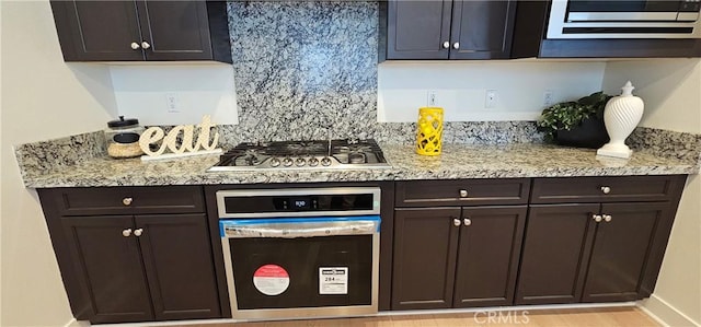 5232 Las Palmas Way, Chino, CA 91710 - kitchen featuring black oven, stainless steel gas stovetop, dark brown cabinetry, light stone countertops, and baseboards