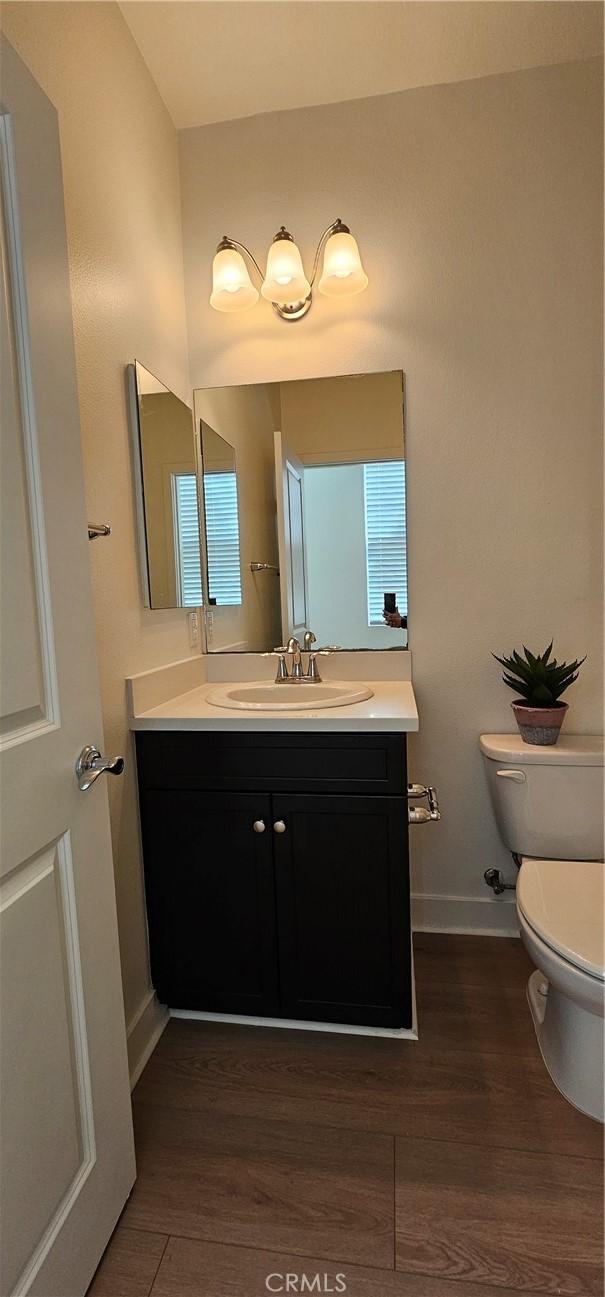 5232 Las Palmas Way, Chino, CA 91710 - half bath featuring toilet, vanity, wood finished floors, and baseboards