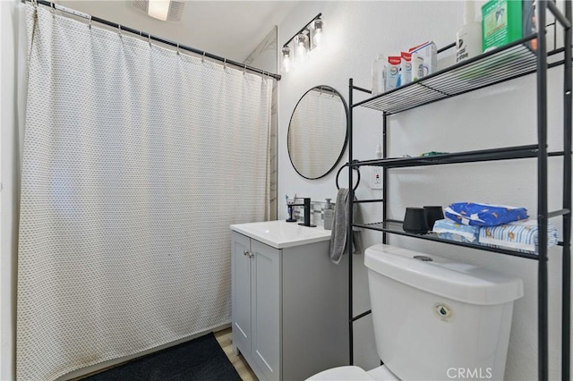 bathroom featuring a shower with curtain, toilet, vanity, and visible vents