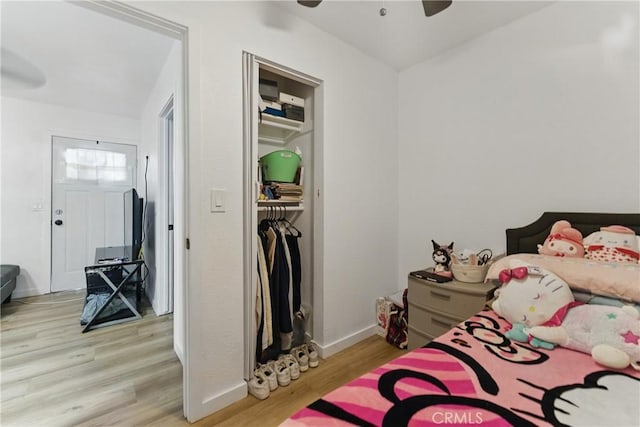 bedroom featuring baseboards, wood finished floors, and a ceiling fan