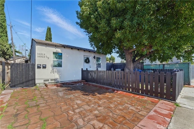 back of property with stucco siding and fence private yard