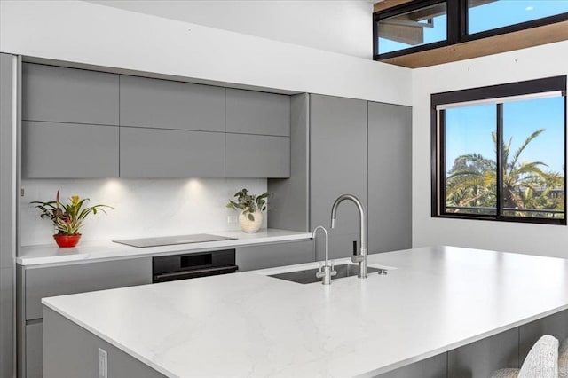 2677 State St # 301, Carlsbad, CA 92008 - kitchen featuring gray cabinets, modern cabinets, an island with sink, and black appliances