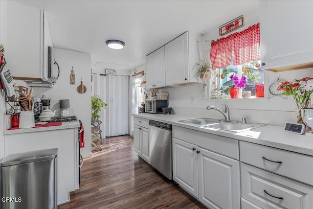 kitchen with white cabinets, light countertops, a sink, and appliances with stainless steel finishes