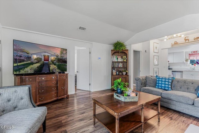 living room featuring wood finished floors, baseboards, vaulted ceiling, and visible vents