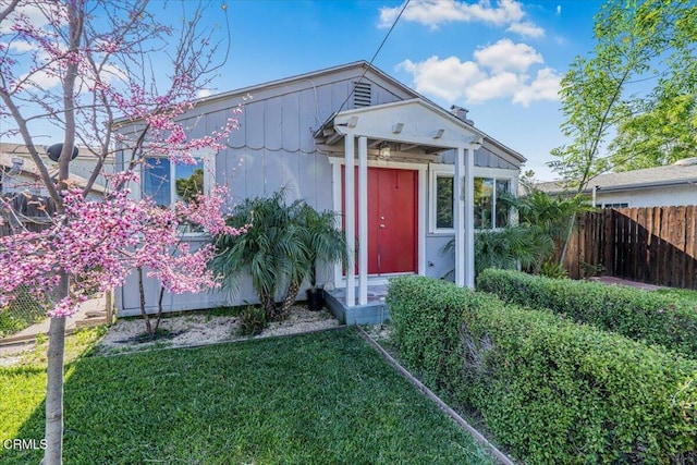 view of front of house featuring a front lawn and fence