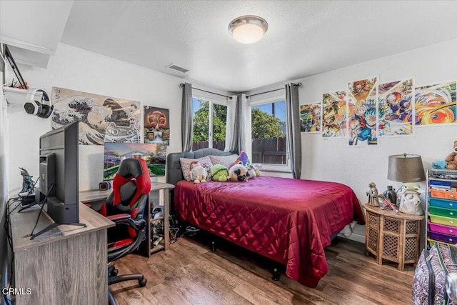 bedroom with wood finished floors and visible vents