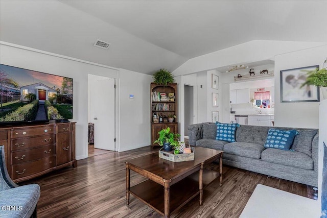 living area with dark wood-style flooring, vaulted ceiling, and visible vents