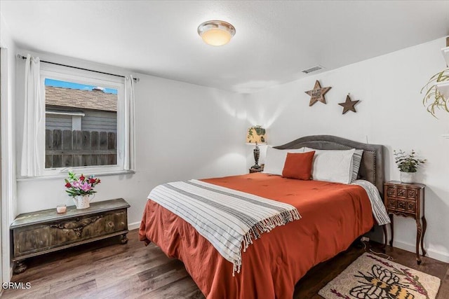 bedroom featuring baseboards, visible vents, and wood finished floors