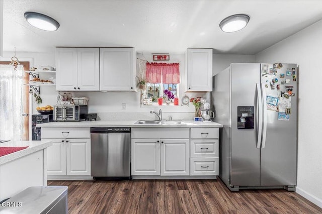 kitchen with a sink, white cabinets, appliances with stainless steel finishes, and dark wood-style floors