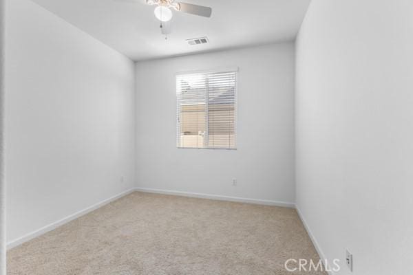 unfurnished room featuring a ceiling fan, carpet, baseboards, and visible vents