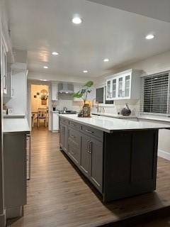 340 Foxenwood Dr, Santa Maria, CA 93455 - kitchen featuring glass insert cabinets, recessed lighting, a center island, wood finished floors, and light countertops
