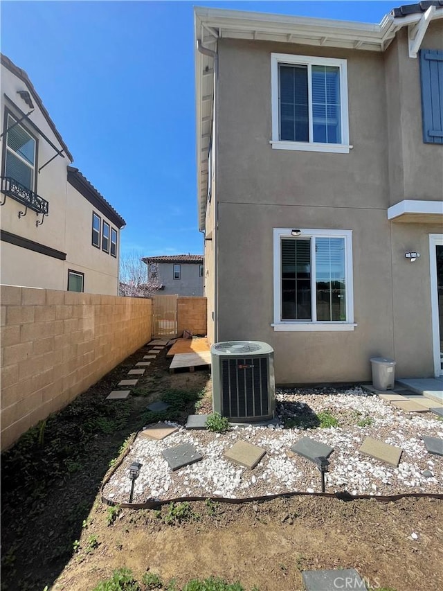 1406 Girona Dr, Pomona, CA 91766 - rear view of property featuring central AC unit, stucco siding, and fence