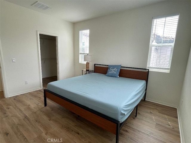 1406 Girona Dr, Pomona, CA 91766 - bedroom featuring baseboards, visible vents, a spacious closet, and wood finished floors