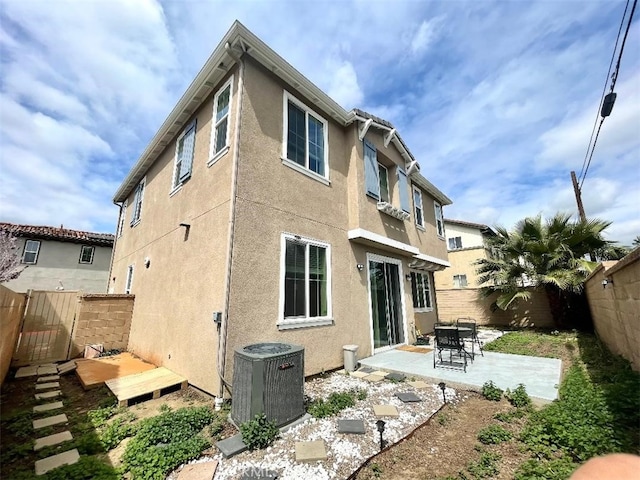 1406 Girona Dr, Pomona, CA 91766 - back of house with a fenced backyard, stucco siding, central air condition unit, and a patio