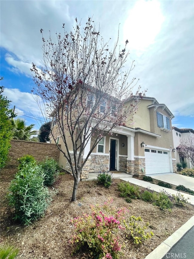 1406 Girona Dr, Pomona, CA 91766 - view of front facade with stone siding, concrete driveway, stucco siding, fence, and a garage