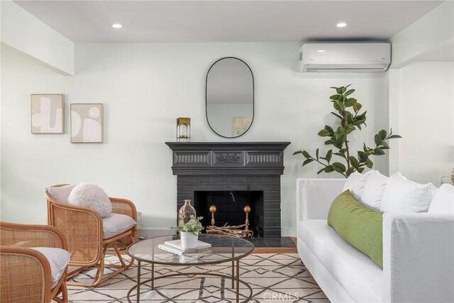 2902 Ladoga Ave, Long Beach, CA 90815 - living room featuring a wall mounted AC, recessed lighting, a brick fireplace, and wood finished floors