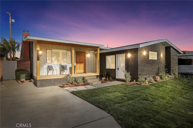 2902 Ladoga Ave, Long Beach, CA 90815 - view of front facade featuring a front lawn, covered porch, and a chimney