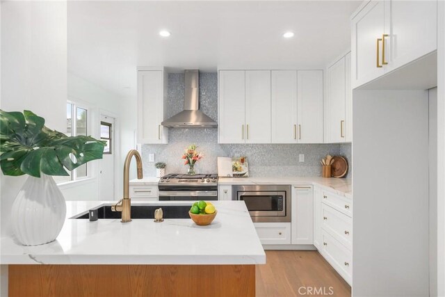 2902 Ladoga Ave, Long Beach, CA 90815 - kitchen featuring wall chimney exhaust hood, appliances with stainless steel finishes, tasteful backsplash, white cabinets, and recessed lighting