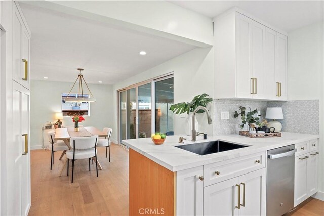 2902 Ladoga Ave, Long Beach, CA 90815 - kitchen featuring a sink, stainless steel dishwasher, white cabinetry, decorative backsplash, and light wood-type flooring