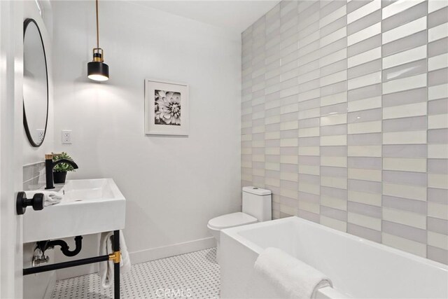 2902 Ladoga Ave, Long Beach, CA 90815 - bathroom with a tub to relax in, toilet, baseboards, and tile patterned floors