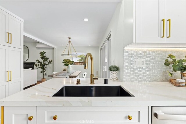 2902 Ladoga Ave, Long Beach, CA 90815 - kitchen featuring a sink, tasteful backsplash, white cabinetry, light stone counters, and decorative light fixtures