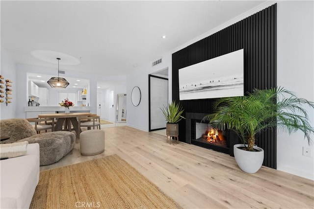 2233 Martin Unit 212, Irvine, CA 92612 - living area with a lit fireplace, visible vents, wood finished floors, and recessed lighting