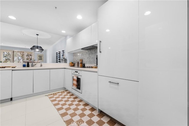 2233 Martin Unit 212, Irvine, CA 92612 - kitchen with light countertops, white oven, white cabinetry, and decorative light fixtures