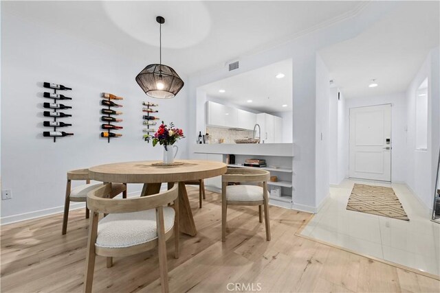 2233 Martin Unit 212, Irvine, CA 92612 - dining room featuring light wood-type flooring and ornamental molding