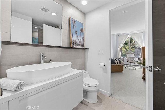 2233 Martin Unit 212, Irvine, CA 92612 - bathroom featuring visible vents, toilet, tile walls, recessed lighting, and connected bathroom