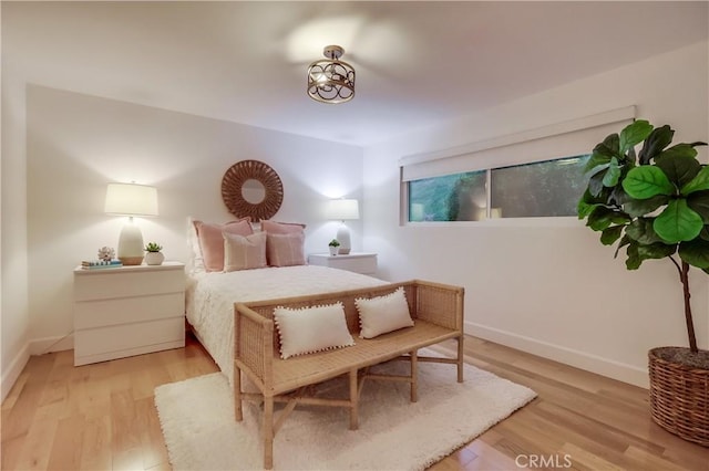 bedroom with baseboards and wood finished floors