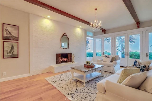 living area with an inviting chandelier, beam ceiling, baseboards, light wood-style floors, and recessed lighting