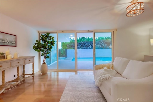 living room with floor to ceiling windows, plenty of natural light, wood finished floors, and baseboards