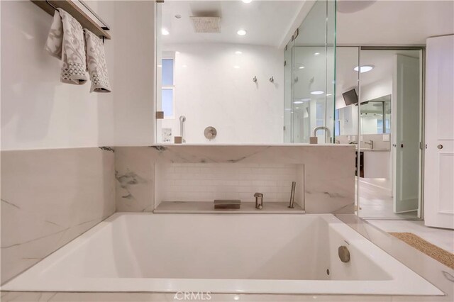 full bathroom featuring a garden tub and recessed lighting