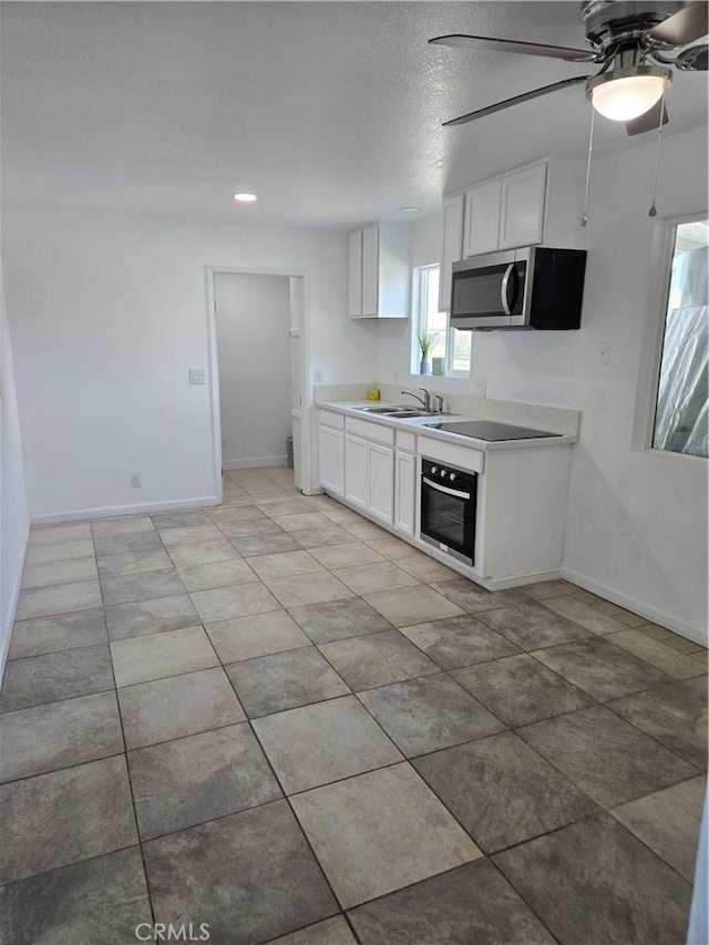 902 Boxwood Ln, Lemoore, CA 93245 - kitchen featuring stainless steel microwave, wall oven, ceiling fan, and white cabinets