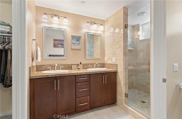 615 Rockefeller, Irvine, CA 92612 - bathroom featuring a walk in closet, double vanity, a shower stall, and tile patterned flooring