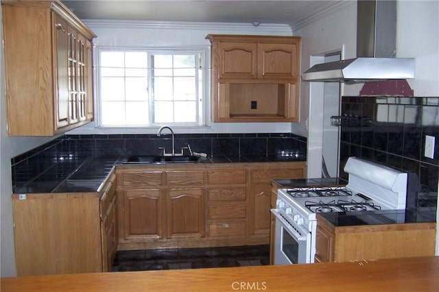 1208 W 23rd St, San Bernardino, CA 92405 - kitchen with wall chimney exhaust hood, gas range gas stove, crown molding, dark countertops, and brown cabinets